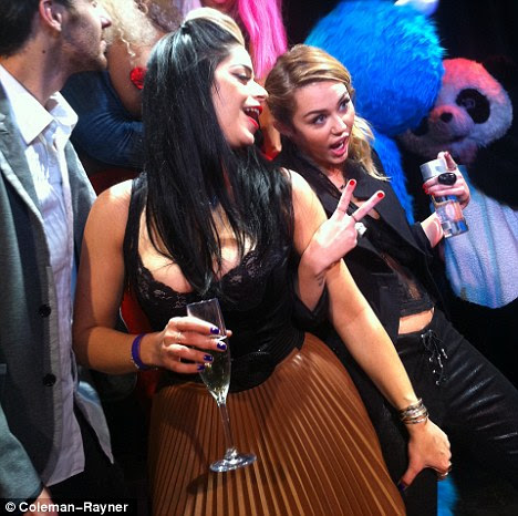 Cat cool: Miley pisca um sinal de paz quando ela entra no espírito de festa com um amigo