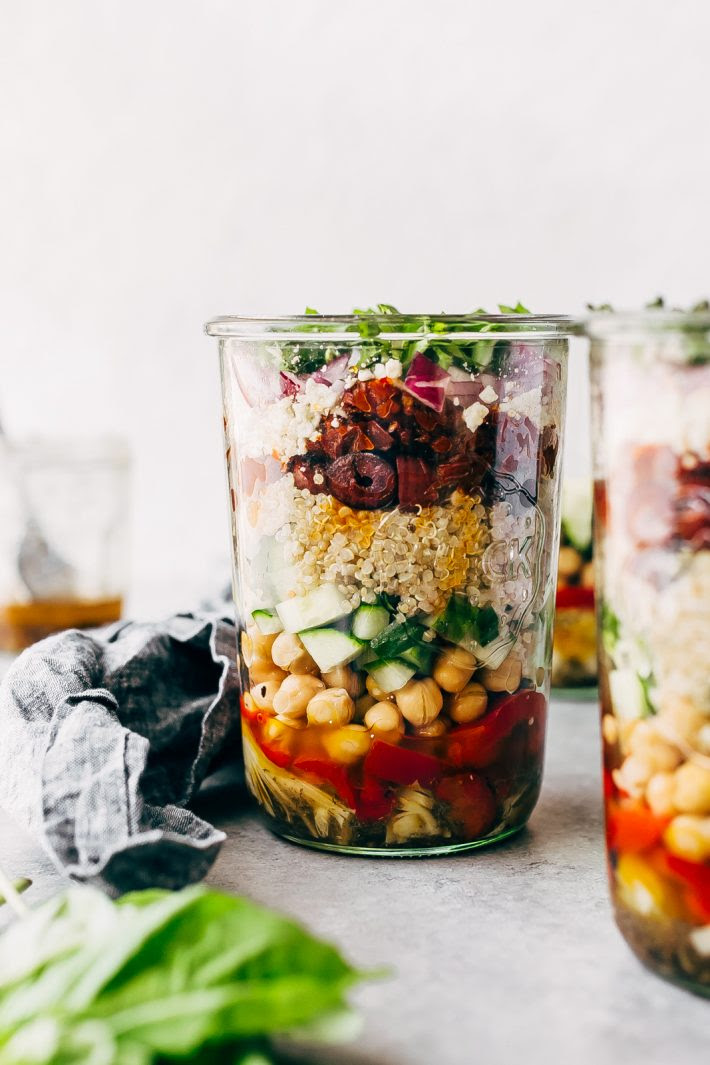 Greek Quinoa Salad Jars - these jars are prefect for meal prepping and popping them in the refrigerator for the week ahead. Swap the ingredients for ones you like, this is so customizable! #saladjars #greeksaladjars #quinoasaladjars | Littlespicejar.com