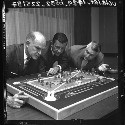 William Frederickson Jr., Robert Howe and William T. Wright examining model of planned redesign of Pershing Square, Calif., 1964
