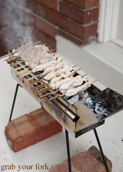 yakitori chicken skewers on an arrosticini charcoal grill at a stomachs eleven japanese dinner