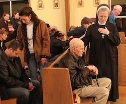 Laicos y religiosas imponen manos orando por sus hermanos