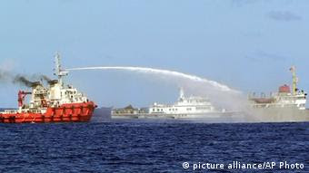 , a Chinese ship, left, shoots water cannon at a Vietnamese vessel, right, while a Chinese Coast Guard ship, center, sails alongside in the South China Sea, off Vietnam's coast, Wednesday, May 7, 2014. Chinese ships are ramming and spraying water cannons at Vietnamese vessels trying to stop Beijing from setting up an oil rig in the South China Sea, according to Vietnamese officials and video evidence Wednesday, a dangerous escalation of tensions in disputed waters considered a global flashpoint.