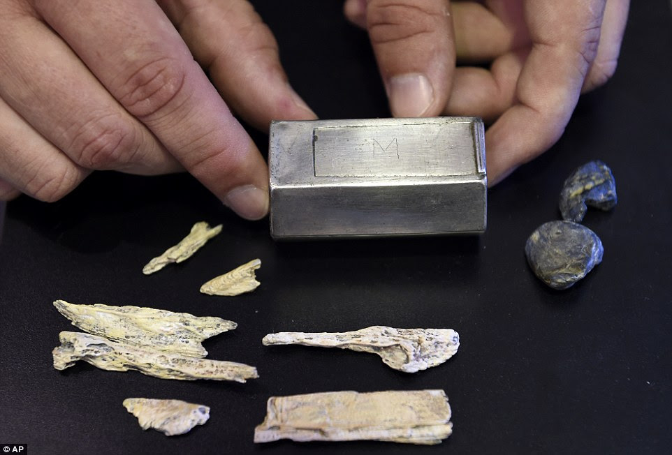 A well-preserved silver box believed to be a Catholic reliquary is displayed at the Smithsonian's National Museum of Natural History in Washington, Tuesday, July 28, 2015. The box was found resting on top of the coffin of Capt. Gabriel Archer at the site of the 1608 Anglican church at the historic Jamestown colony site in Virginia. The box is surrounded by replicas of what is believed to be inside the firmly sealed box--seven bone fragments and two pieces of a lead ampulla, a container used to hold holy water.