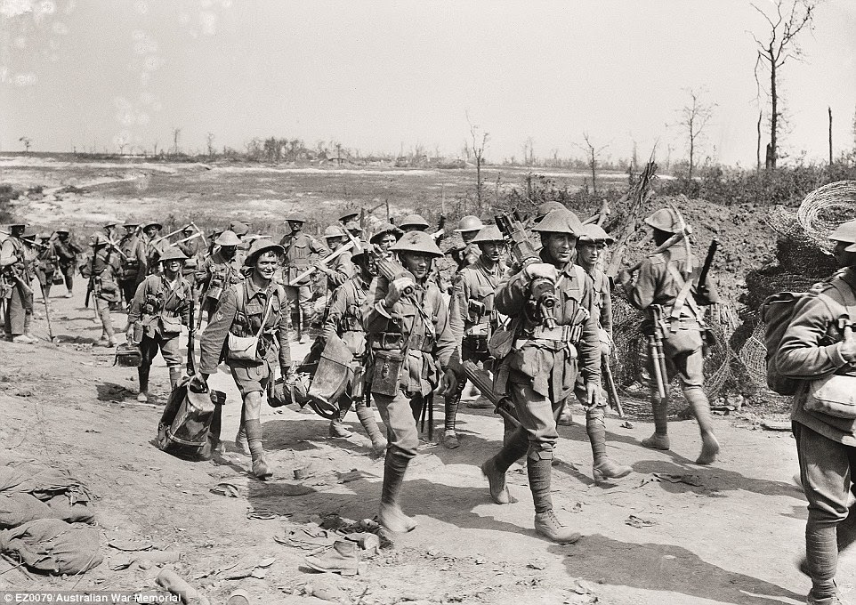 Men going into and coming out of action. Two Australian columns pass at Casualty Corner on the road up to the Pozières battlefield. Those in the foreground are members of a machine-gun company