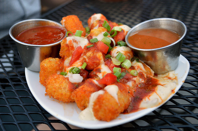 Tots a la Cruz - spiced tater tots, smoked cheese sauce, salsa, tomatoes and green onions