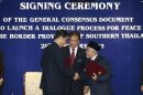 Pattanathabutr of Thailand's NSC and Hassan of Thailand's BRN liason office in Malaysia shake hands as they exchange documents during a signing ceremony in Kuala Lumpur