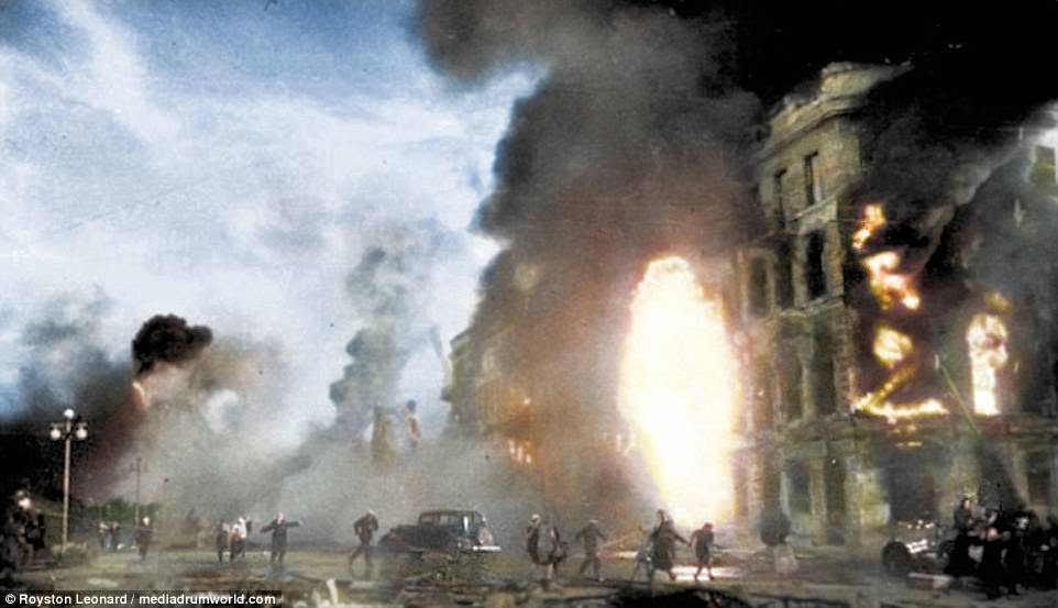 When the Soviet forces finally broke through the German ranks in 1943 they left behind a city in ruins. These colourised photos depict that city - left hollow after five months of constant shelling, fire and famine. This photo, originally from the German Federal Archive, shows a skirmish in the street against the backdrop of a burning apartment block
