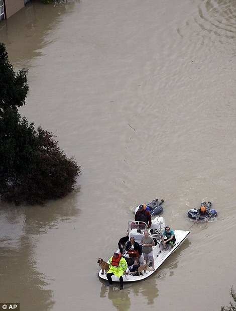 Volunteers on boats toe people on rubber rings (left) to safety as a man carries a woman through the floods (right)