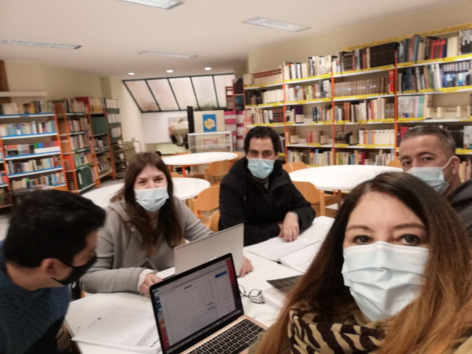 A group of people sitting at a table with a computer

Description automatically generated with medium confidence