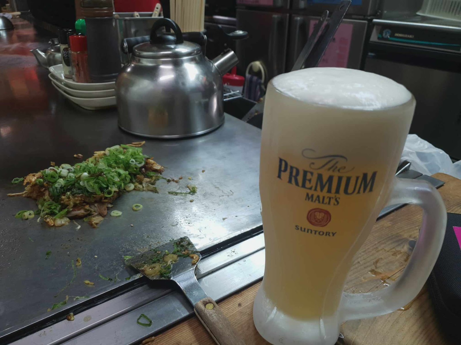 ice cold suntory premium draft beer and okonomiyaki on teppan