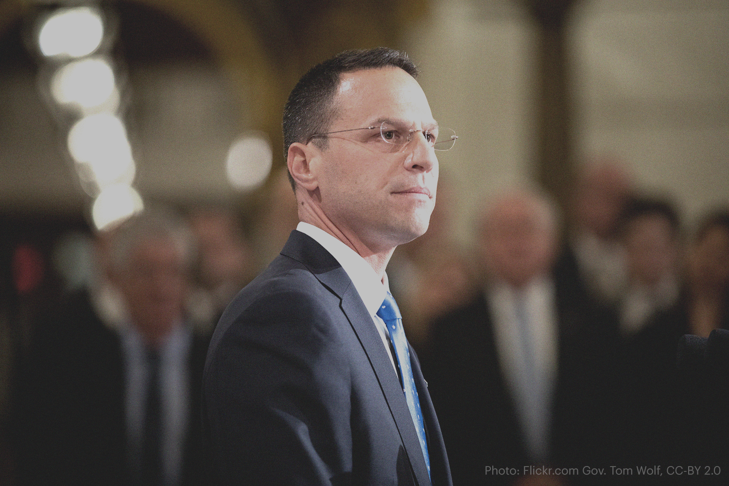 Governor Josh Shapiro stands in a suit looking off into the distance.