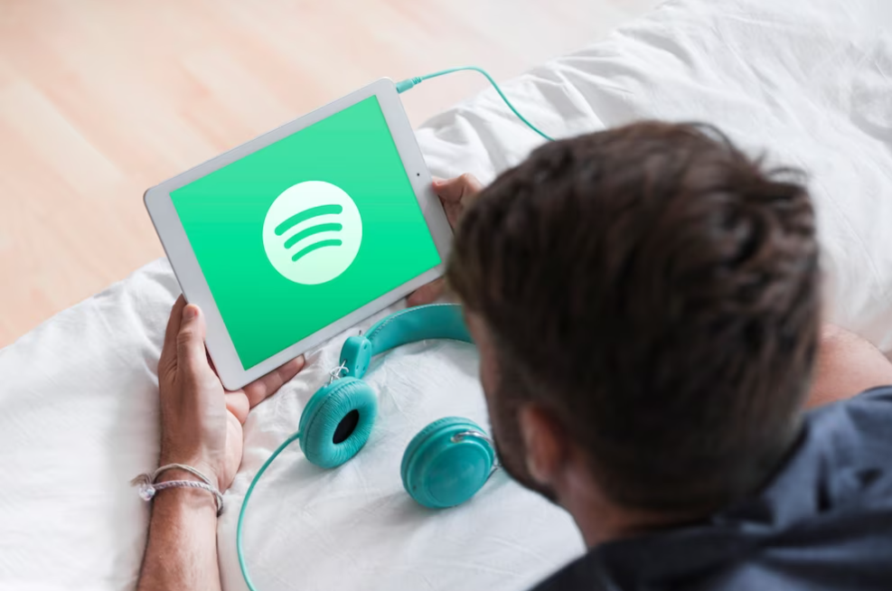 man holding device with Spotify app on it