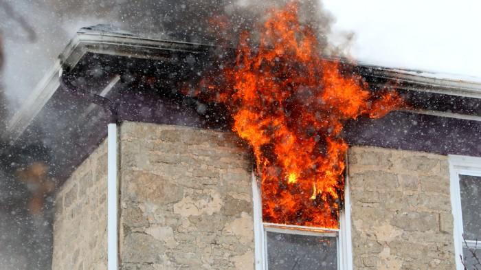 Fire rising from a home window.