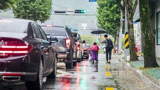 지난 9월 구미역 인근에서 한 청년이 비를 맞고 걸어가던 할머니에게 우산을 씌워주고 있다. 이 청년은 경일대학교 소방방재학부 2학년 김규민씨로 확인됐다. /경북문화신문 제공