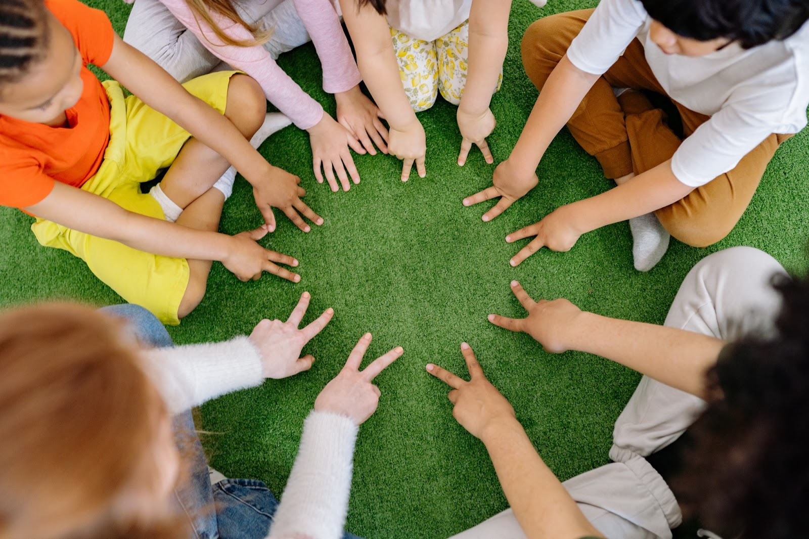 Children sitting in circle with teacher playing a finger game 