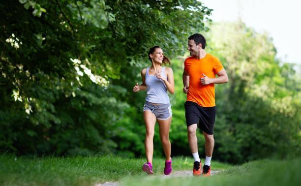 Portrait of happy fit people running together ourdoors. Couple sport healthy lifetsyle concept Portrait of happy young fit people running together ourdoors. Couple sport healthy lifetsyle concept jogging stock pictures, royalty-free photos & images