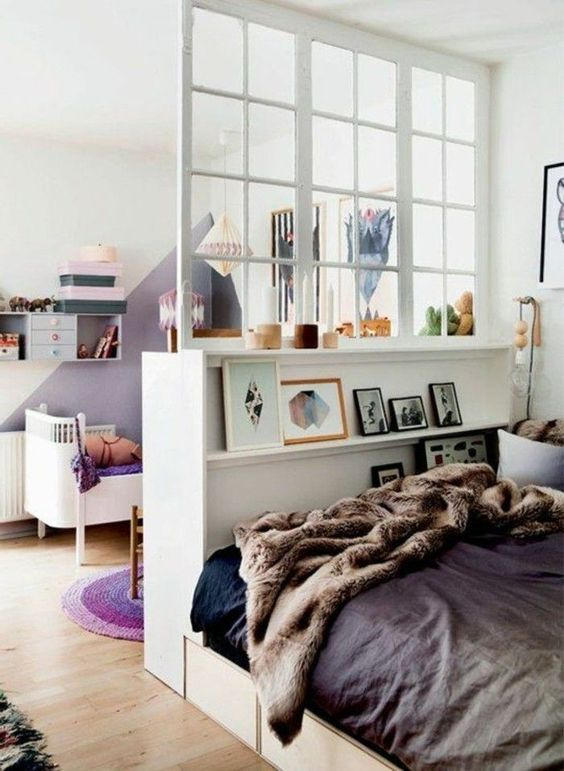 A bookcase bed headboard can delineate a sleeping area while offering useful storage. Image Source: Pinterest. ALT: Create separate areas for different activities by introducing a bookcase bed headboard that divides a room. This is one way to style a bookcase bed.