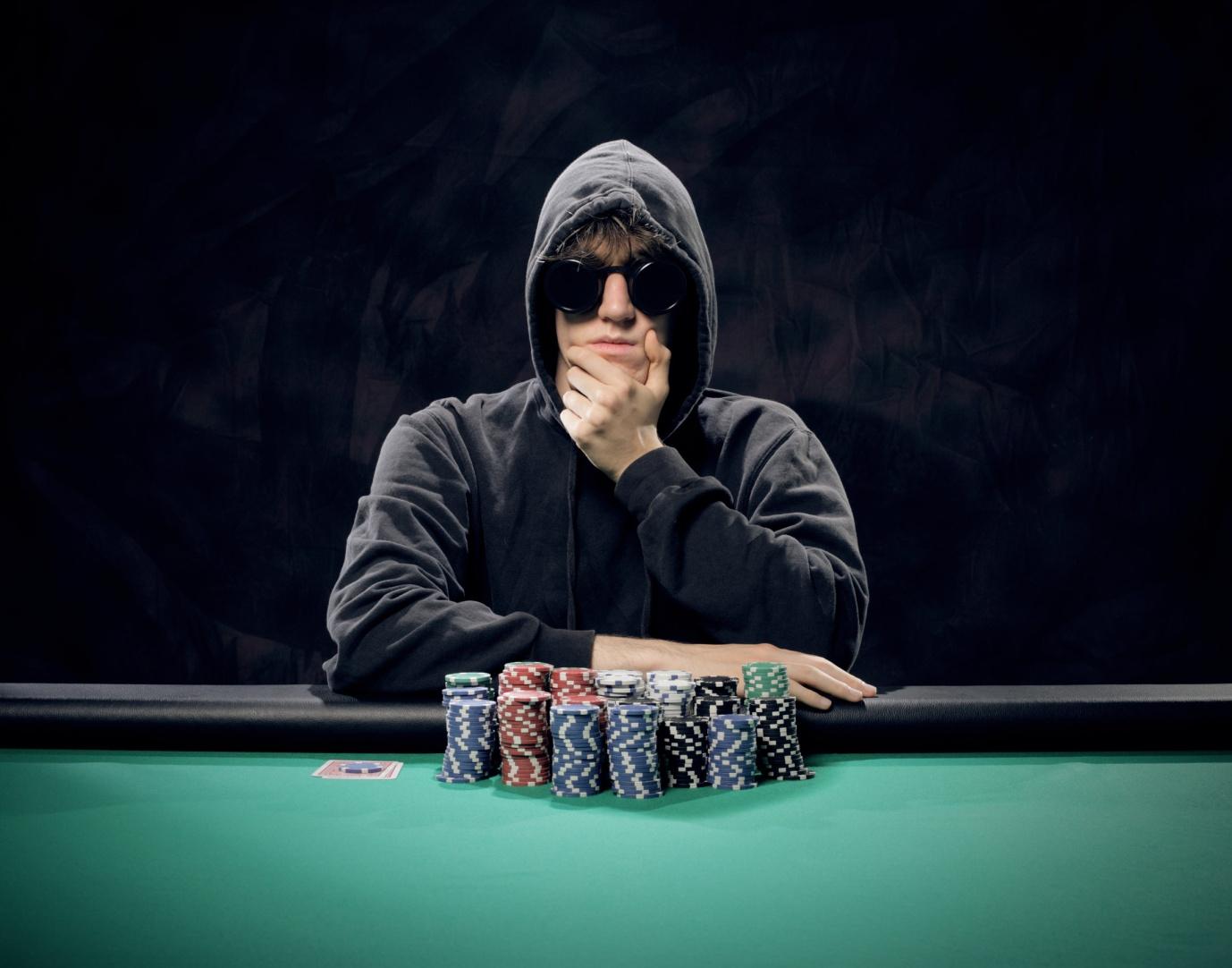 A person wearing a mask and sitting at a table with poker chips

Description automatically generated with low confidence