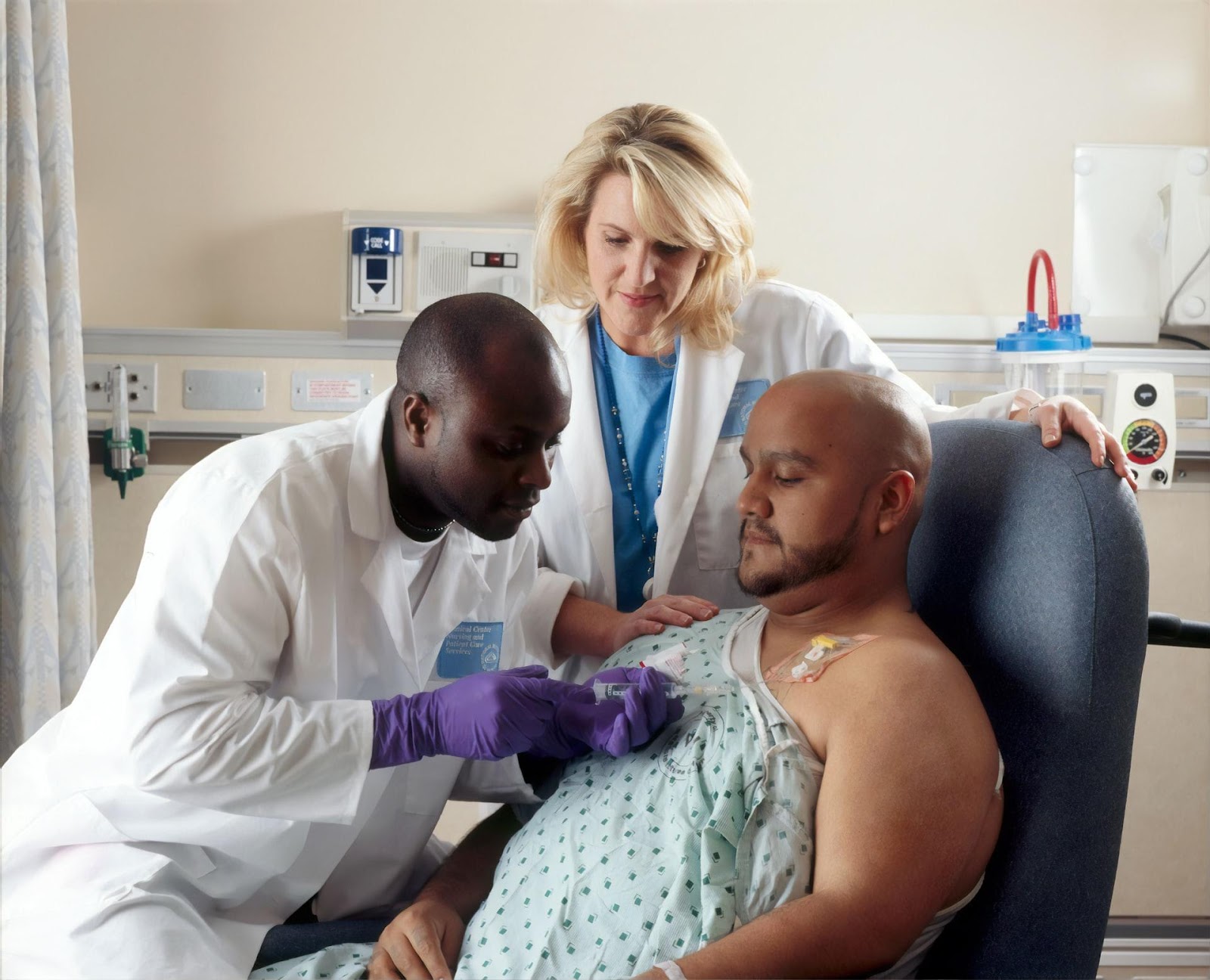 A picture of two physicians working together to help assist a patient in a procedure