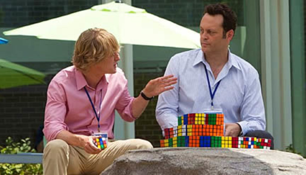 Picture of Owen Wilson and Vince Vaughn working at Google because of their employer brand; deep in conversation behind Rubik's cubes