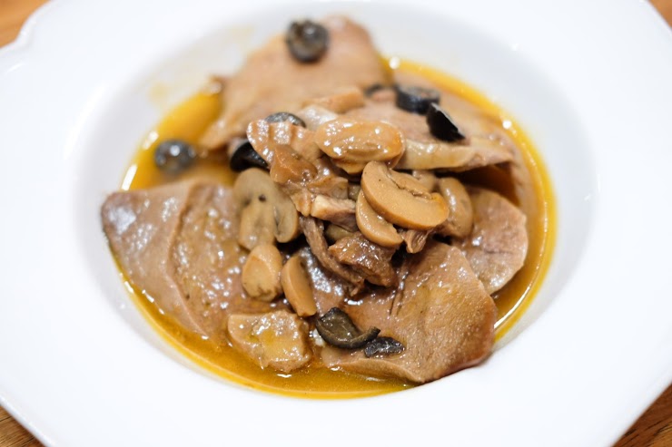 Ox tongue slow-cooked in rum, topped with mushrooms and olives.  