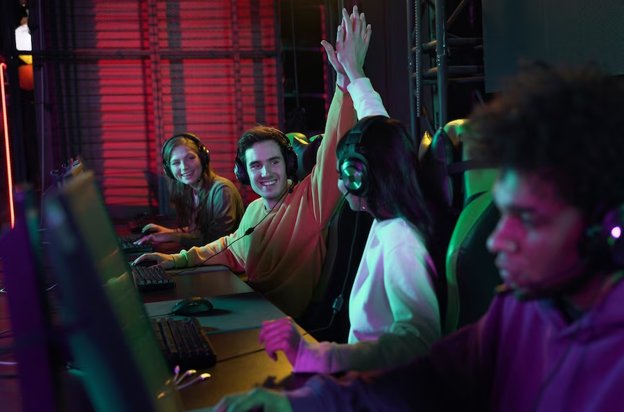 Group of people using computers, with two individuals giving each other a high five
