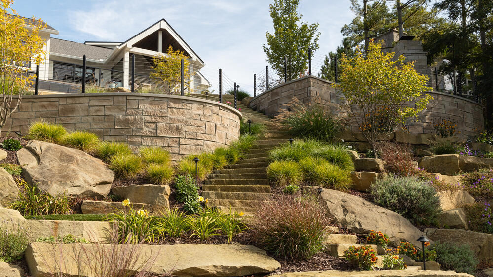 Indiana Limestone garden steps harmoniously blend with the natural look of the sandstone boulders and rustic Berkshire™ veneer.