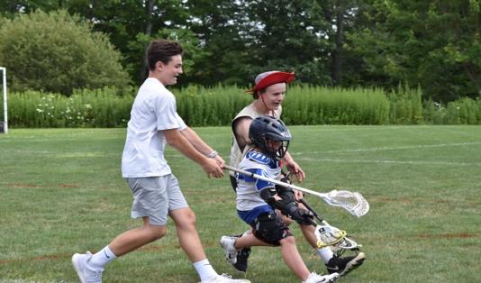 A young boy playing football on a field
Description automatically generated
