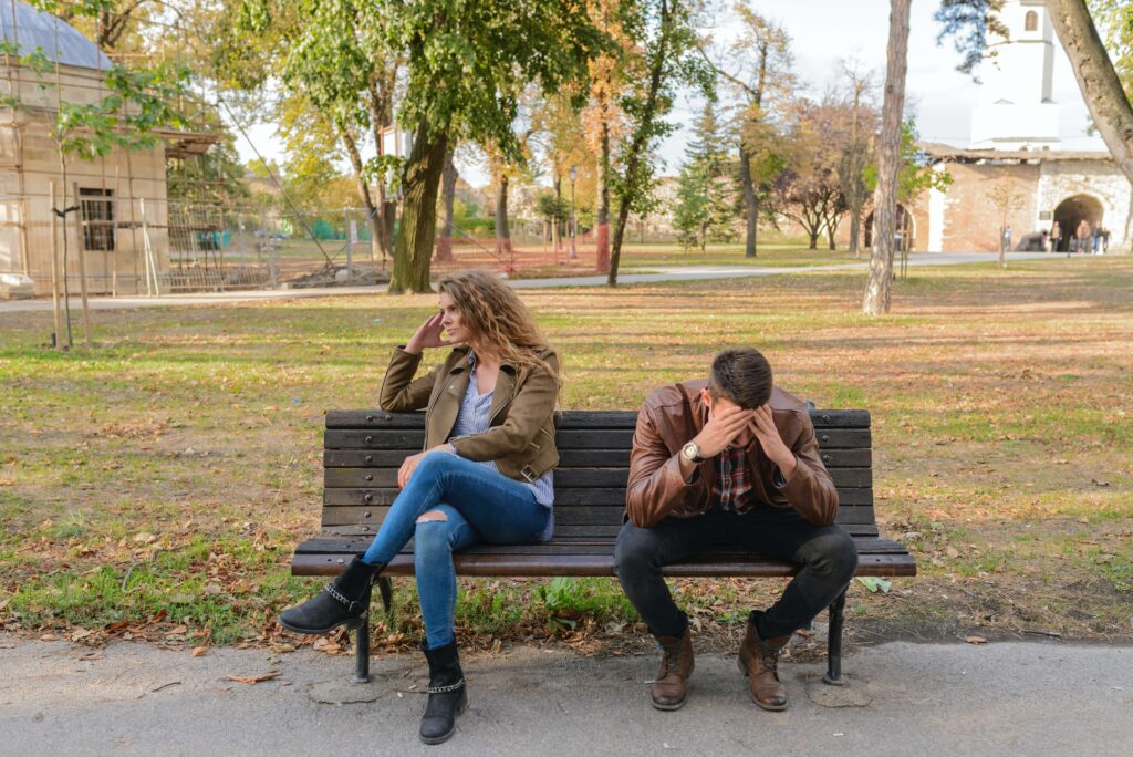 Why relationships that move fast fail article, woman with a man sitting back to back on a bench