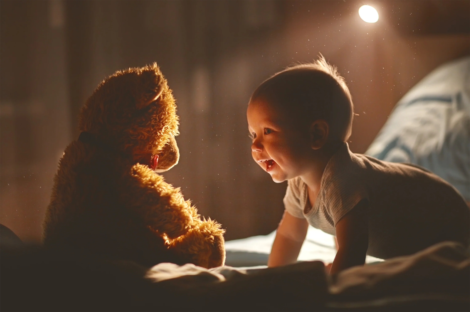 A cute baby crawling, happily towards an adorable cuddly bear. 