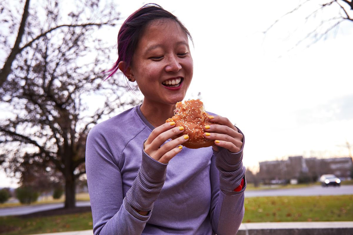 woman wearing running clothes holds an impossible whopper