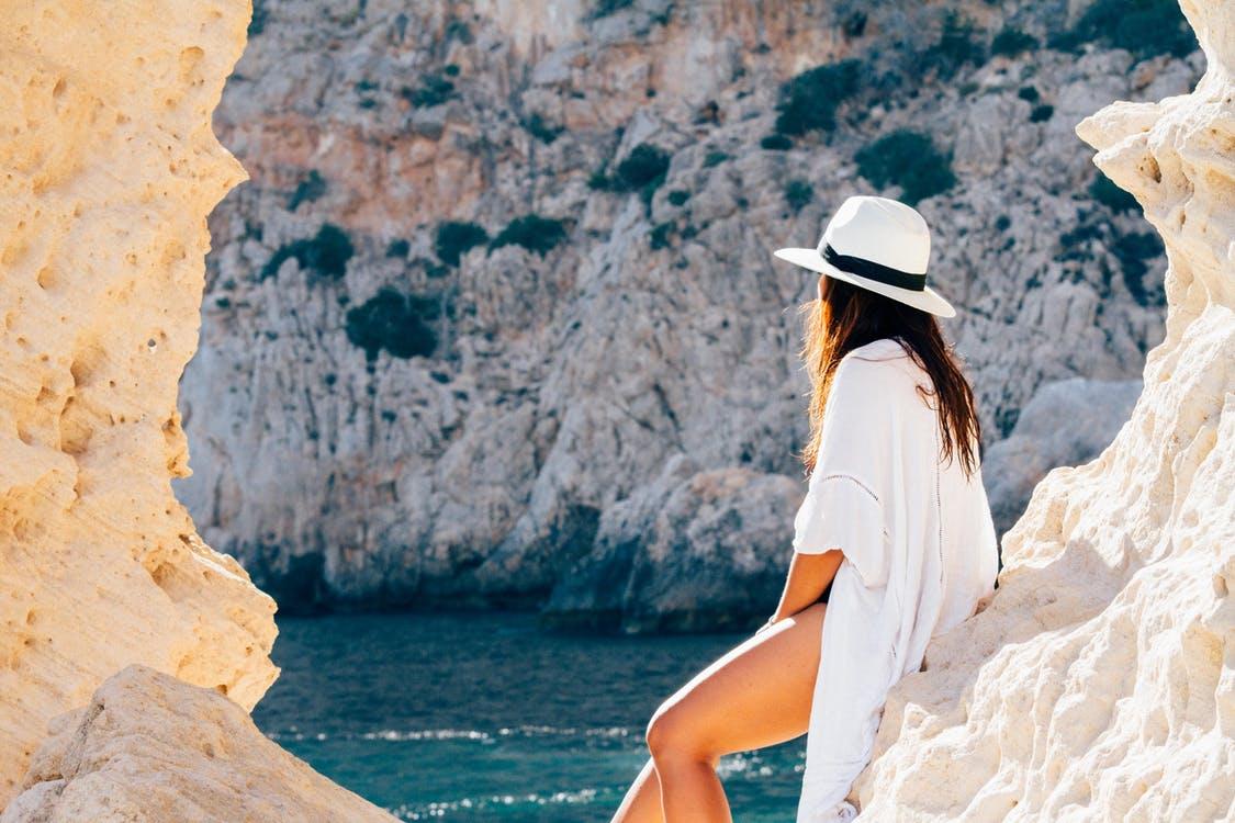 Free Rear View of Woman Sitting on a rock Stock Photo