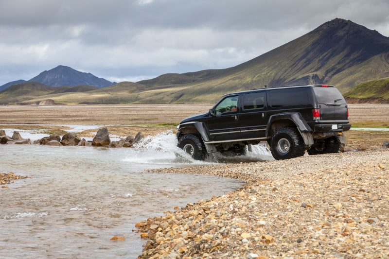 A black car driving through a river