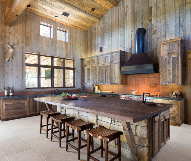 large cabin kitchen with wood accents and oversized island with butcher block and stone siding