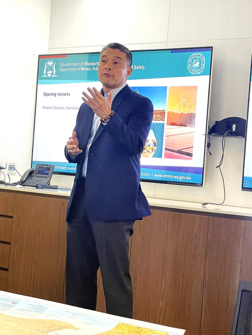 A person standing in front of a screenDescription automatically generated with medium confidence