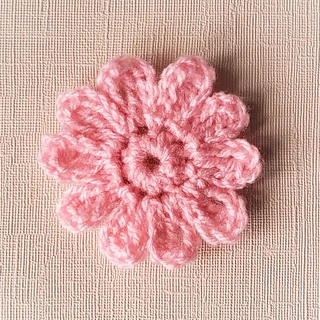 pink crochet flower on fabric background