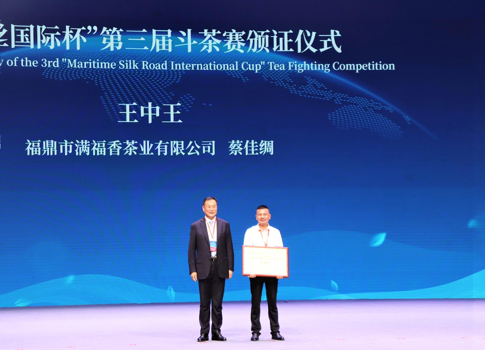图5：宁德市委书记梁伟新（左）为“海丝国际杯”第三届斗茶赛王中王获得者颁证。叶茂 摄