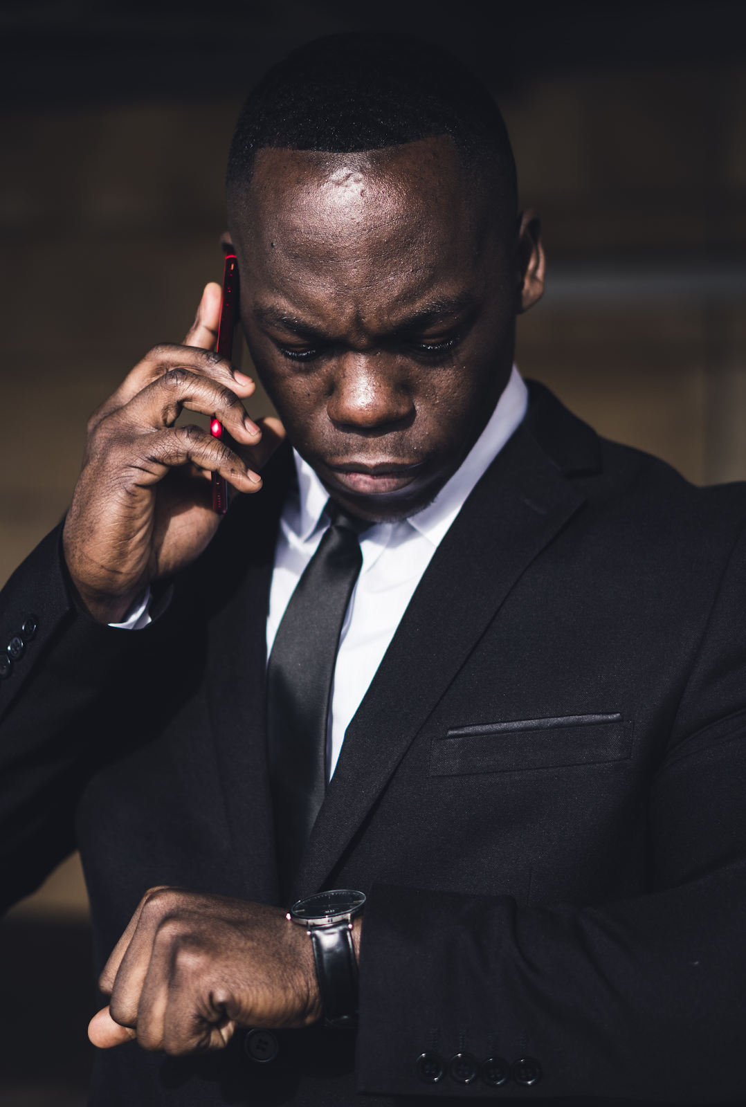 Man in black formals looking at his wrist watch