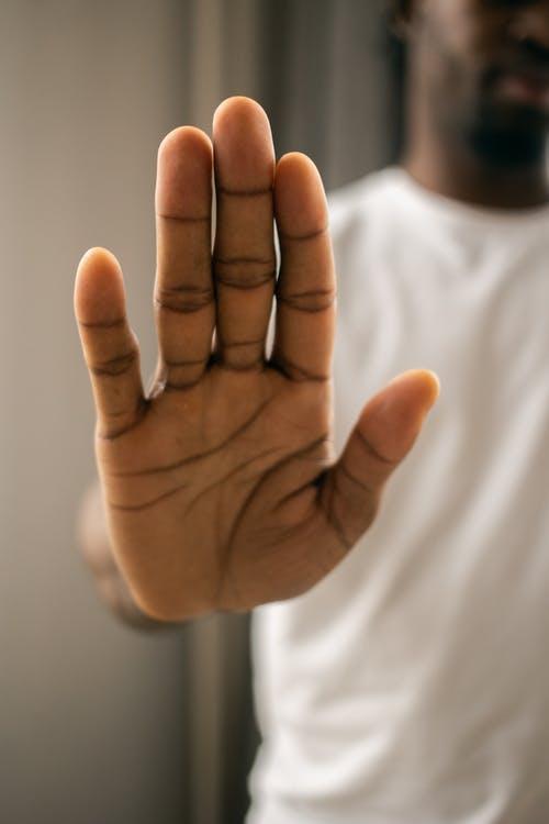 Free Faceless black man showing stop gesture with hand Stock Photo