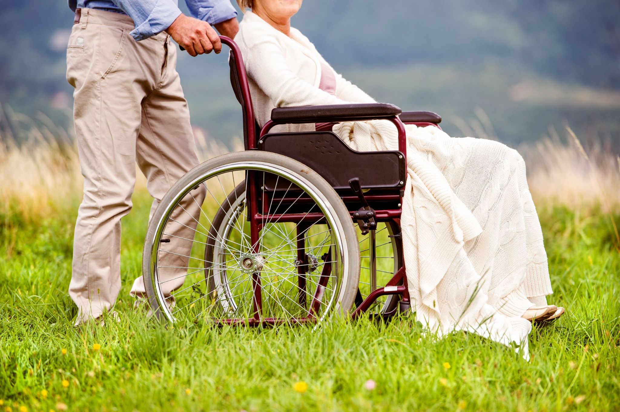 older-man-pushing-older-woman-in-wheelchair-outdoors