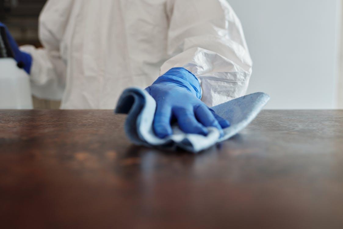 Close-Up Photo Of Person Cleaning The Table
