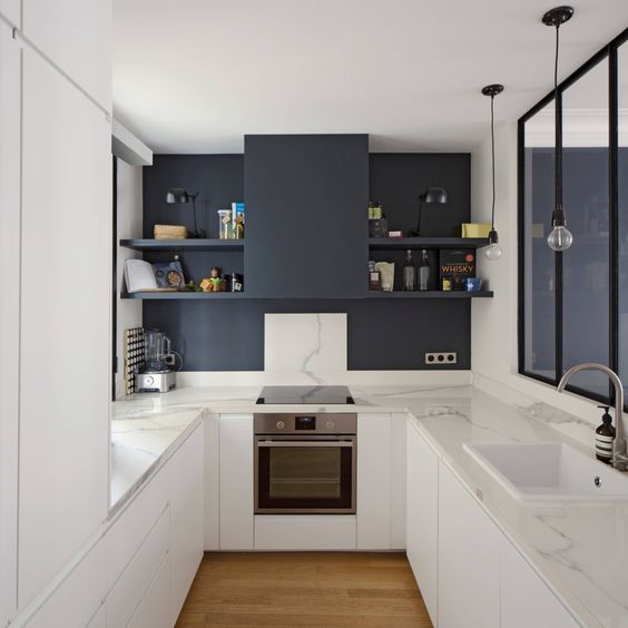 navy and white u-shaped modern kitchen with flat panel cabinets, pendant lighting and open shelving