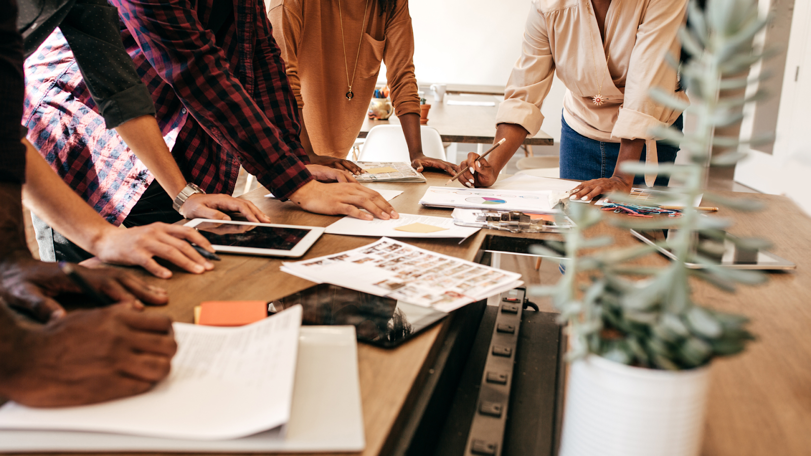 four people strategizing at a table and making plans