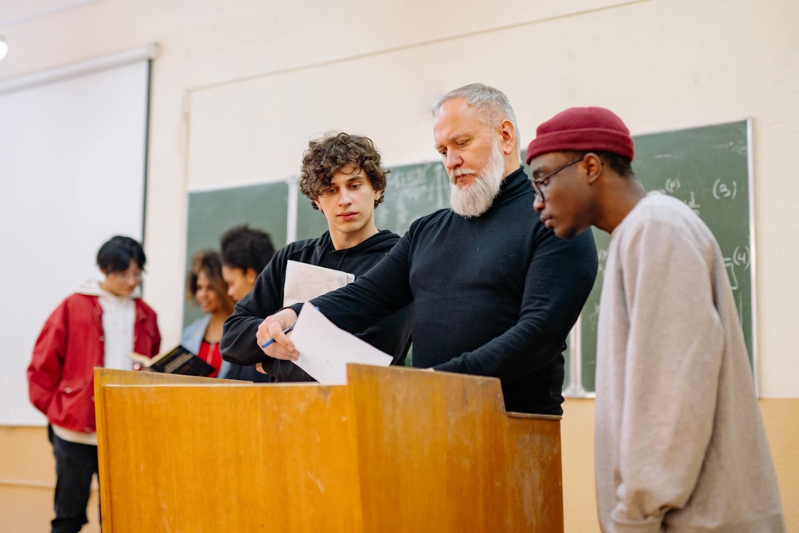 High school students going over papers with their teacher