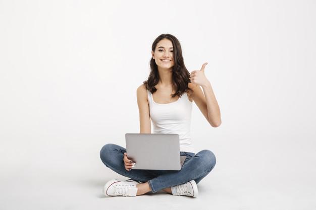 Portrait of a happy woman dressed in tank-top holding laptop Free Photo