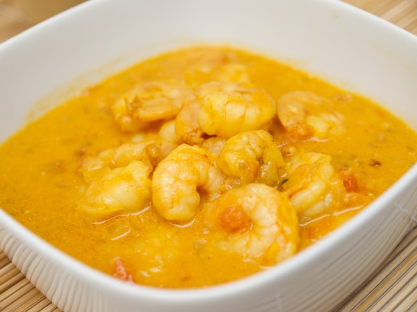 Shrimp coconut curry served on a white square-shaped bowl