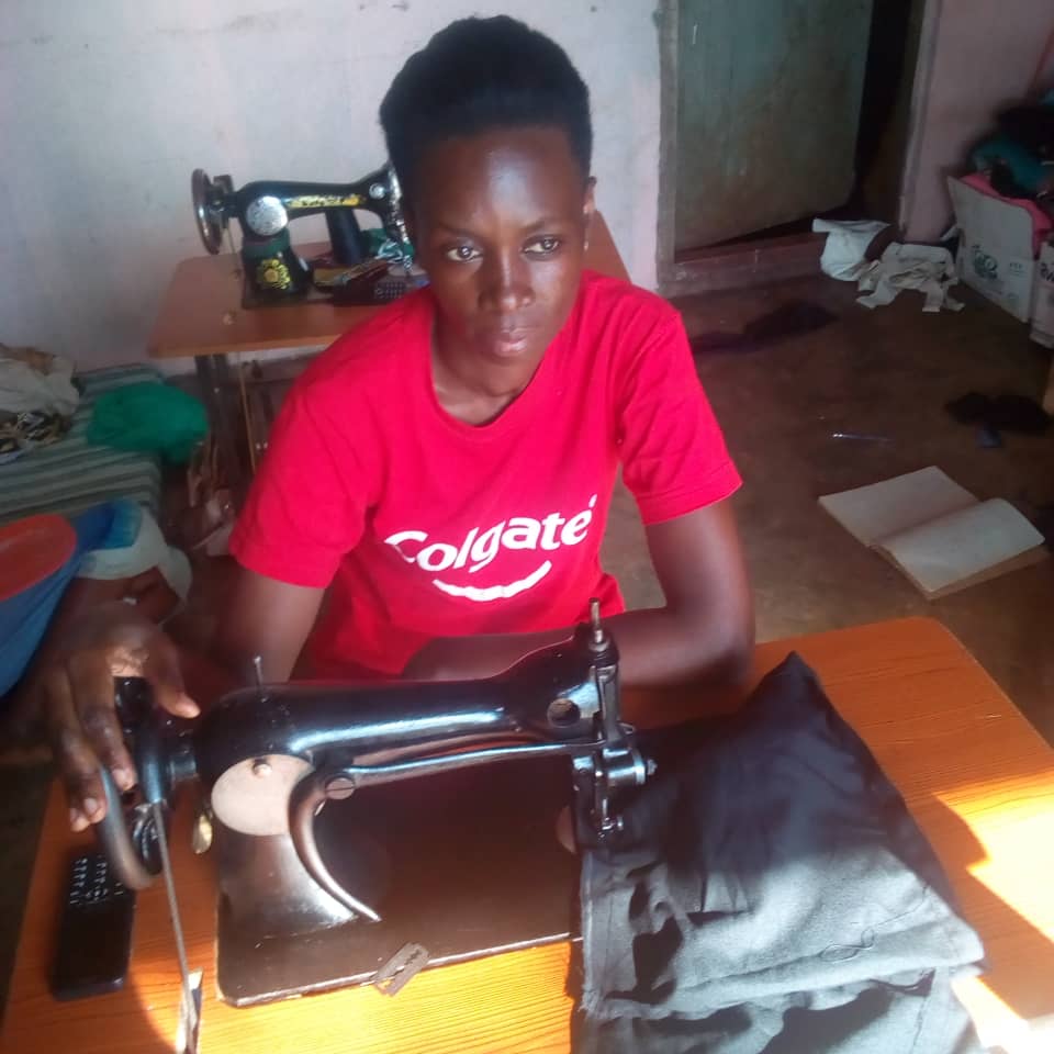 Picture of Gloria and her sewing machine, young Ugandan girl.