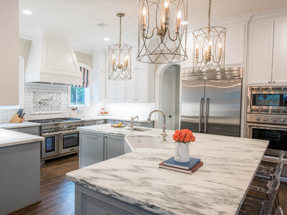 large grey and white contemporary kitchen with pendant lighting white marble countertops and u-shaped island with corner sink