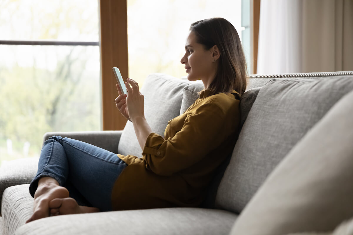 Clinical decision support software: woman sitting on a couch and using her phone