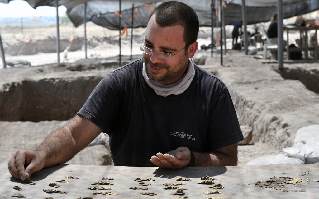 Shahar Krispin, Israel Antiquities Authority coin expert, counts the gold coins (Yoli Schwartz, Israel Antiquities Authority)